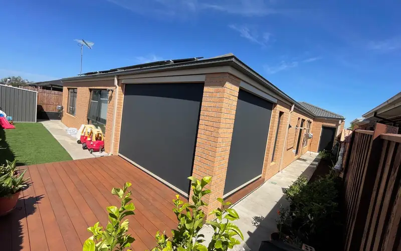 A backyard alfresco with outdoor blinds fitted along the pergola