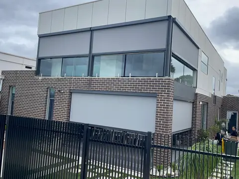Grey outdoor blinds fitted to an upper-level balcony on a modern home