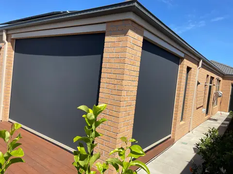 Charcoal outdoor blind wrapping the corner of a brick alfresco